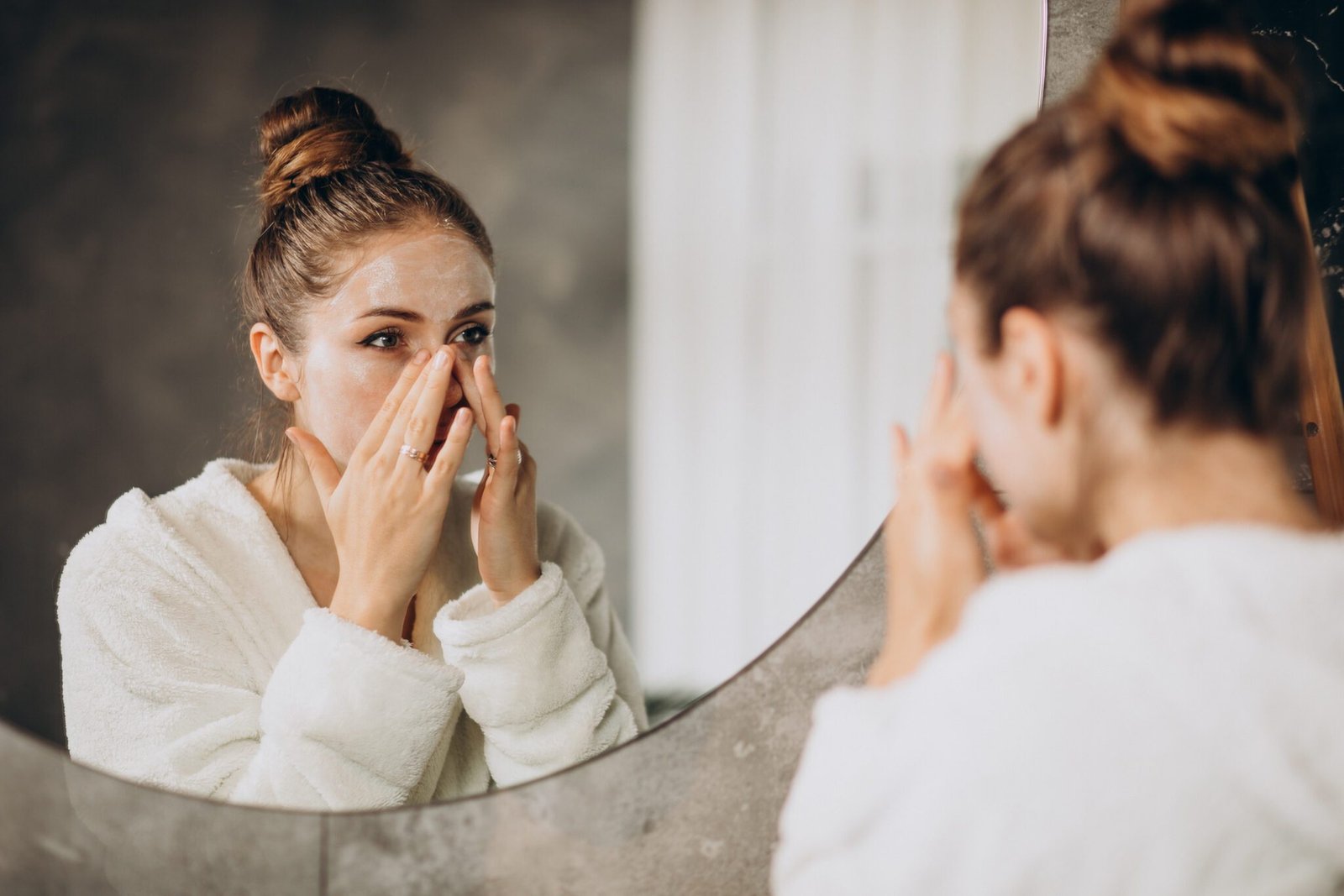 woman at home applying cream mask